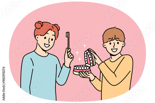 Happy children show rules of brushing teeth and using dental toothbrush to get rid of bacteria in mouth. Little boy and girl advise peers to take care of dental health of teeth and gums.