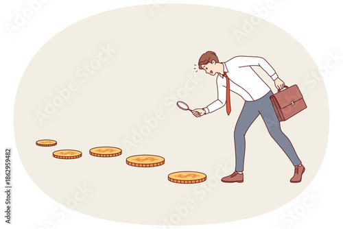 Business man looking for investment opportunities, following trail of gold coins and holding magnifying glass in hands. Investor wants to achieve investment goal and financial growth potential