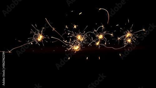 Bright golden sparkler trails and light painting on a black background for New Year celebration or event