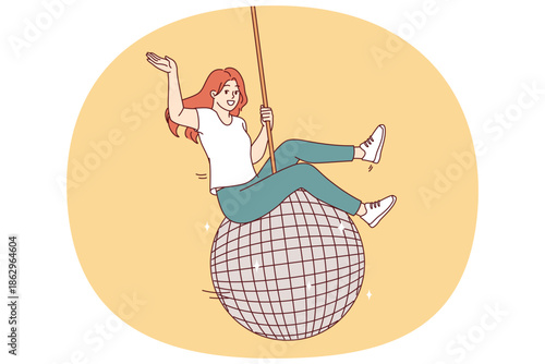 Woman swings on large disco ball and waves hand welcomingly, inviting guests to student party with fiery dancing. Disco ball for dance floor symbolizes great festive rave in nightclub