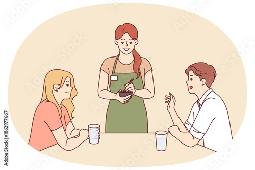 Woman works as waiter in restaurant, stands near table with dice and writes down wishes in notepad. Girl waiter serves guests of cafe, giving recommendations on ordering dishes from menu.