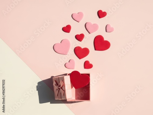 Colorful hearts emerging from a pink gift box on a pastel background for valentines day or love themed designs and promotions