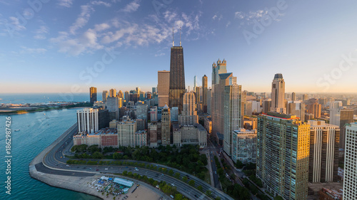 Aerial view of the iconic John Hancock Center and shimmering skyscrapers meeting the tranquil blue of Lake Michigan's shoreline, Chicago, Illinois, United States.