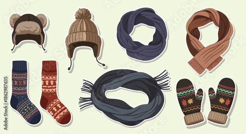 Assorted winter clothing accessories like beanies with pom poms warm scarves patterned socks and cozy mittens in earthy colors.