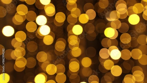 Soft golden bokeh lights create a warm festive background, perfect for Christmas cards, holiday banners, party invitations and elegant seasonal designs with a cozy night atmosphere.