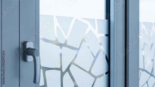 Modern gray window frame with frosted glass detail and metallic handle indoors, close-up.