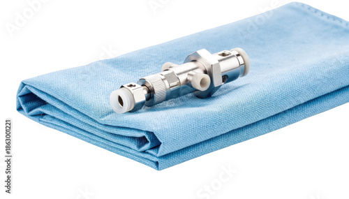 Closeup of a single valve shunt component on blue drape highlighting intricate design and function set against clean white background for clarity in medical explanation.