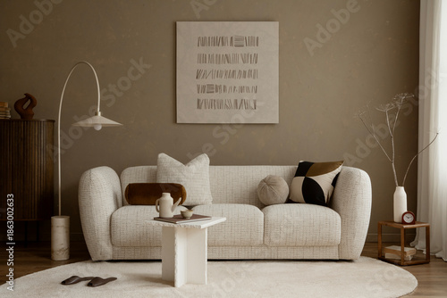 Neutral living room with soft beige sofa, graphic cushion, minimal decor and warm textured wall, styled in contemporary natural tones.
