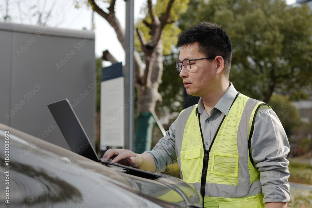 Fototapeta premium asian Worker uses laptop at charging station