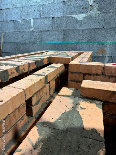 Fresh brickwork of a heating stove ash pit and bench. Smoke channels of the bench are visible. Close-up&