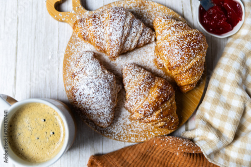 Fresh butter croissants on wooden board with coffee