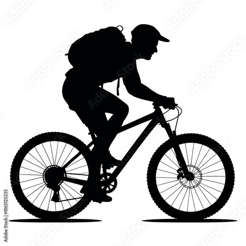 Silhouette of an active cyclist wearing a baseball cap and backpack aggressively riding a mountain bicycle.