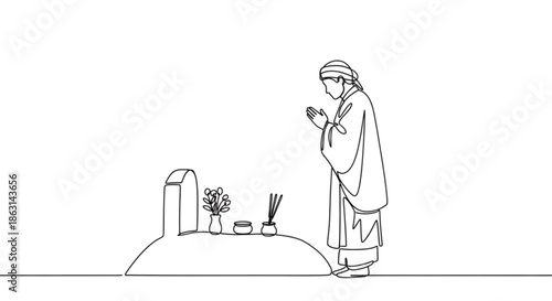 Person praying at a grave with flowers and incense sticks  