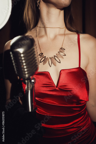 Chanteuse rétro en robe rouge avec son microphone rétro et vintage