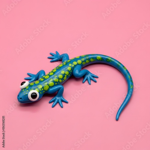 A colorful toy lizard on a pink background