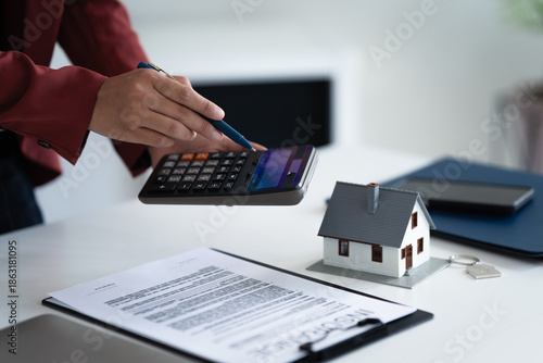 фотографія consultant calculates property valuation and house loan contract in office