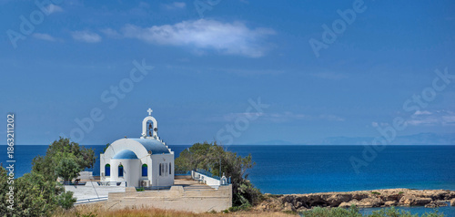 Christian orthodox church with white wall and blue dome at the edge of the bl...