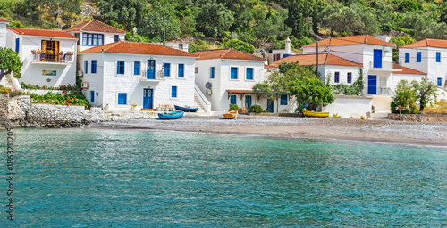 houses with white facades and blue shutters on the edge of a beautiful sea  i...