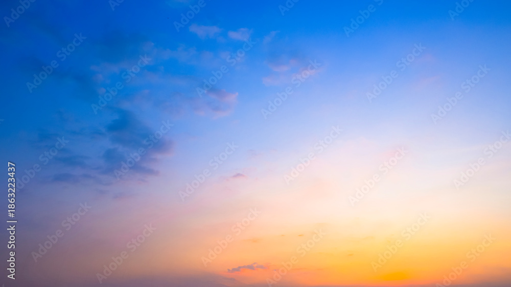 Fototapeta premium Beautiful sunset sky background with soft orange and blue gradient clouds at twilight