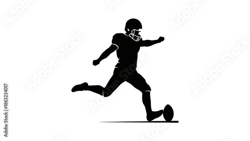 Silhouette of a football player kicking a football during a game.