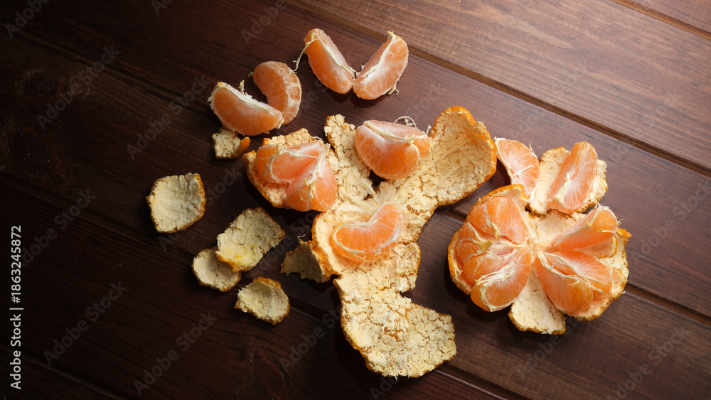 Fototapeta premium Freshly peeled mandarin resting on rustic wooden table