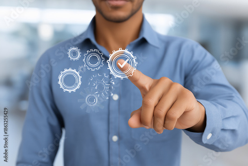 African American man in blue shirt interacting with digital gears and checkmark, symbolizing technology, innovation, and efficiency in a modern workspace environment