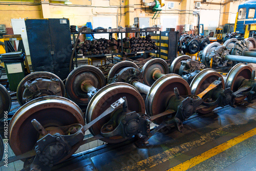 Schilderij op canvas Train wheels and chassis are organized neatly in a railway workshop