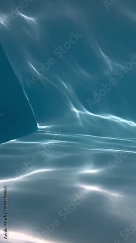 Abstract water surface with shimmering reflections creates a serene, artistic scene. The play of light and shadow evokes a sense of depth and tranquility