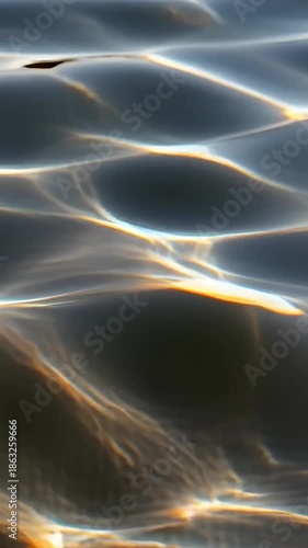 Sparkling water surface with light reflections creating an abstract art style. The interplay of light and shadow, the water's gentle movement, and create a visually captivating, serene.