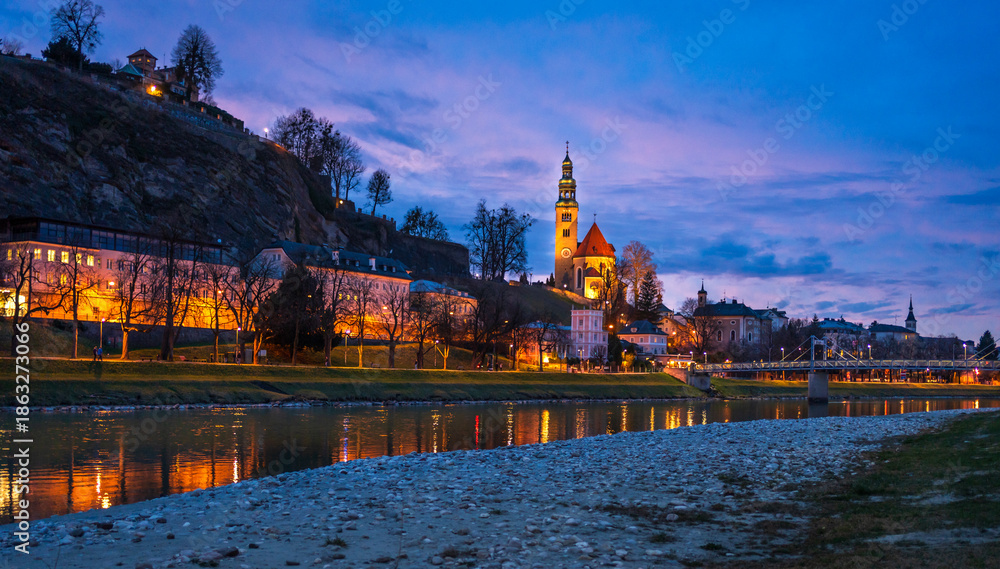Obraz premium Evening view of Salzac River, Salzburg Old town, church in Austria.