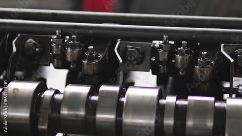 The camshaft and valve train components of a car engine. Mechanics inspect and document metal engine components. An engine mechanism on a work bench in a workshop during professional auto repair.