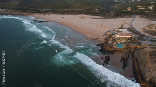 cliffside aquatic haven, turquoise waves crashing ashore, scenic coastal resort overlooking ocean