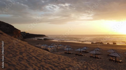 golden hour on deserted shoreline, tranquil sunset overlooking sandy beach