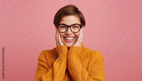 Smiling Woman With Short Hair in Orange Sweater on Pink Background Shows Happ...
