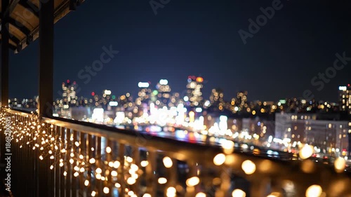 City skyline with lights shining at night from balcony in high-rise building, christmas background