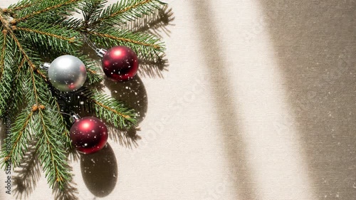 Decorating simple holiday branch with red and silver ornaments in warm indoor setting during festive season, christmas background