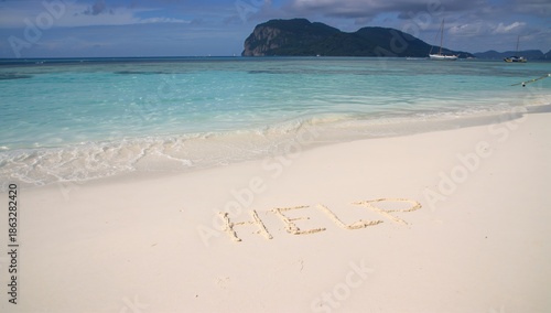 Message Written in Sand Asking for Help on a Beach Near a Small Island