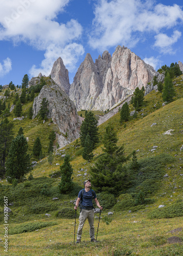 Hiker poses against the backdrop of Sas Rigais peak in the Dolomites