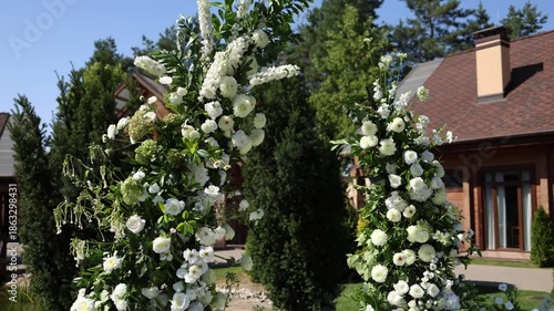 White floral decorative arch outside on a wedding