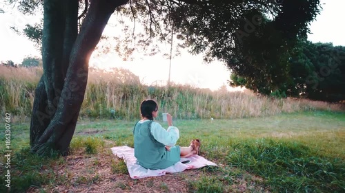Latina woman having a picnic in the park. Using her cell phone. Country style.
