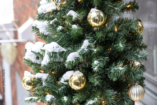 Close-up view of an artificial Christmas tree outdoors after a snowfall