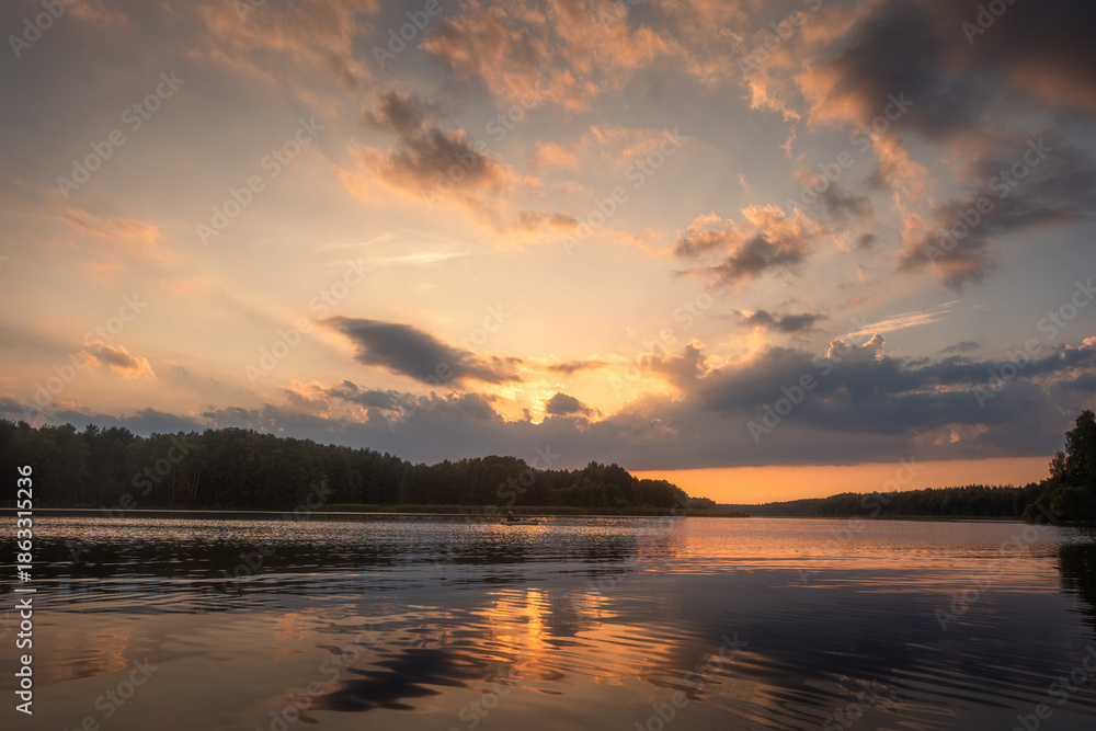 Obraz premium Amazing landscape of lake at colourful sunset with gold clouds as mirror on the surface of water with awasome reflections