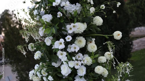 White floral decorative arch outside on a wedding
