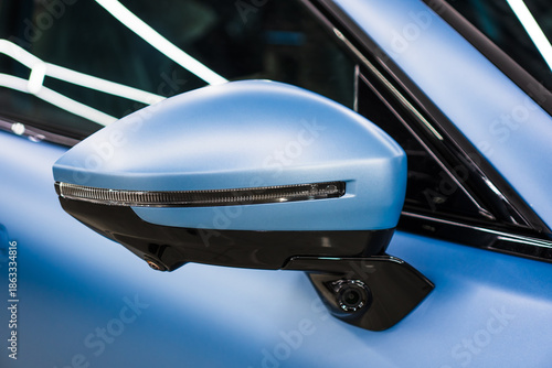 Car side mirror with integrated camera blue car, cam for driver safety and visibility. Car side view camera system integrated into rearview mirror, blind spot detection, 360 visibility. Camera 360. 