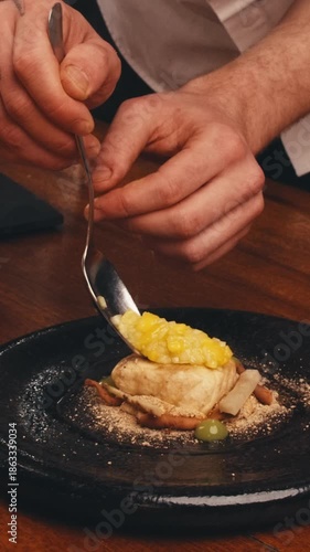dishes of haute cuisine presentation serving details in dishes. chef hands put greens flowers sauce on plate. close up white plate in restaurant. food in Michelin restaurant. modern cooking technology