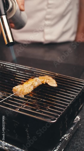 dishes of haute cuisine presentation serving details in dishes. chef hands put grilled shrimps on grill, plate. close up grill in restaurant. food in Michelin restaurant. modern cooking technology
