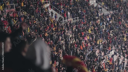 Football crowded stadium full of supporter fans cheering on soccer match, slow motion