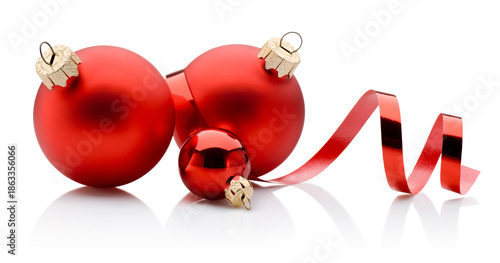 Three red Christmas baubles and curling paper ribbon isolated on white background