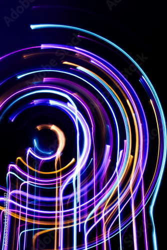 A long exposure photograph. Light painting photography, vibrant fairy lights against a black background