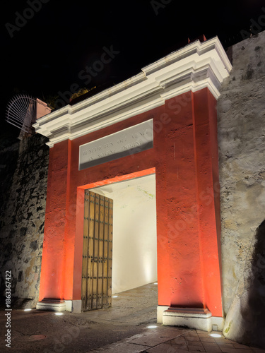 Entrance gate to Old San Juan, known as La Puerta de San Juan lit up at night.